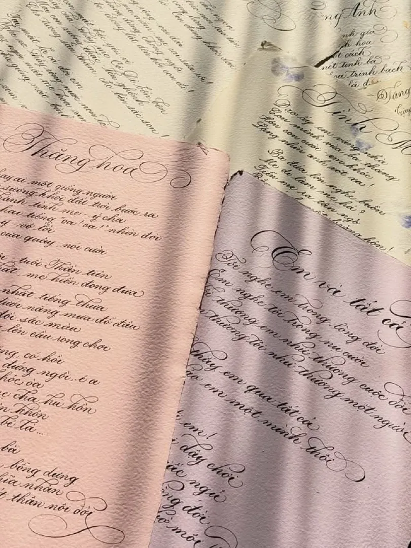 Student work: calligraphy poems on pink and cream paper
