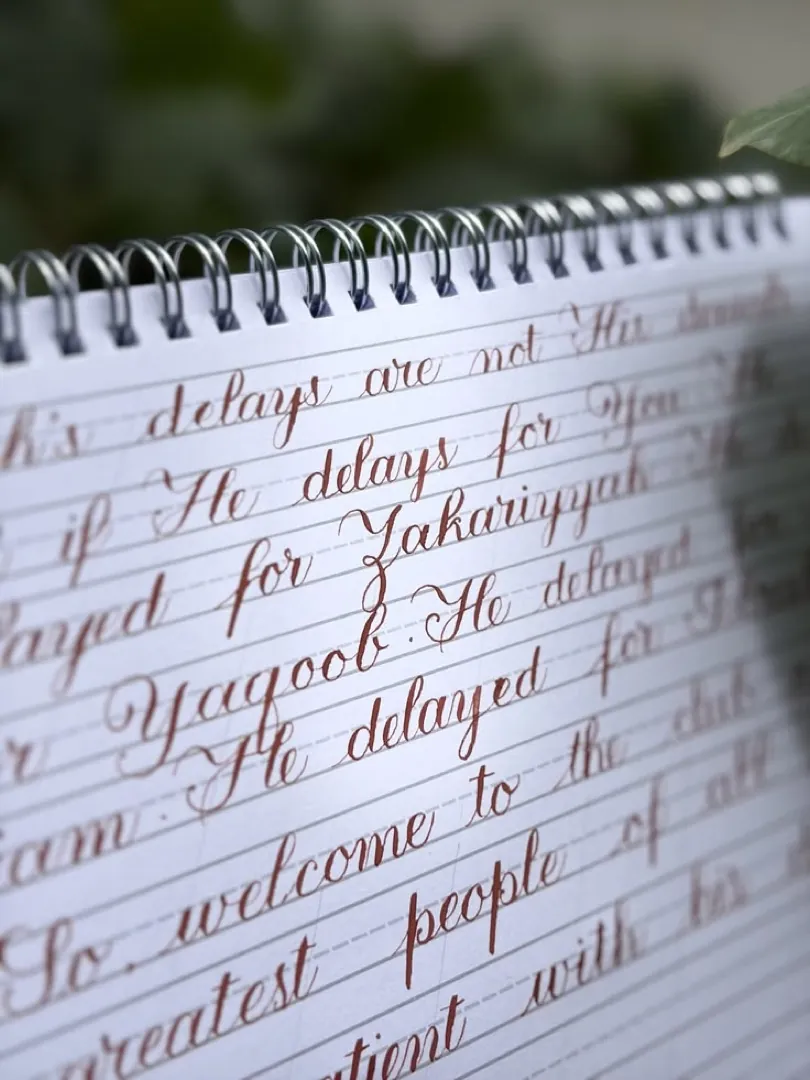 Student work: calligraphy text in a spiral notebook