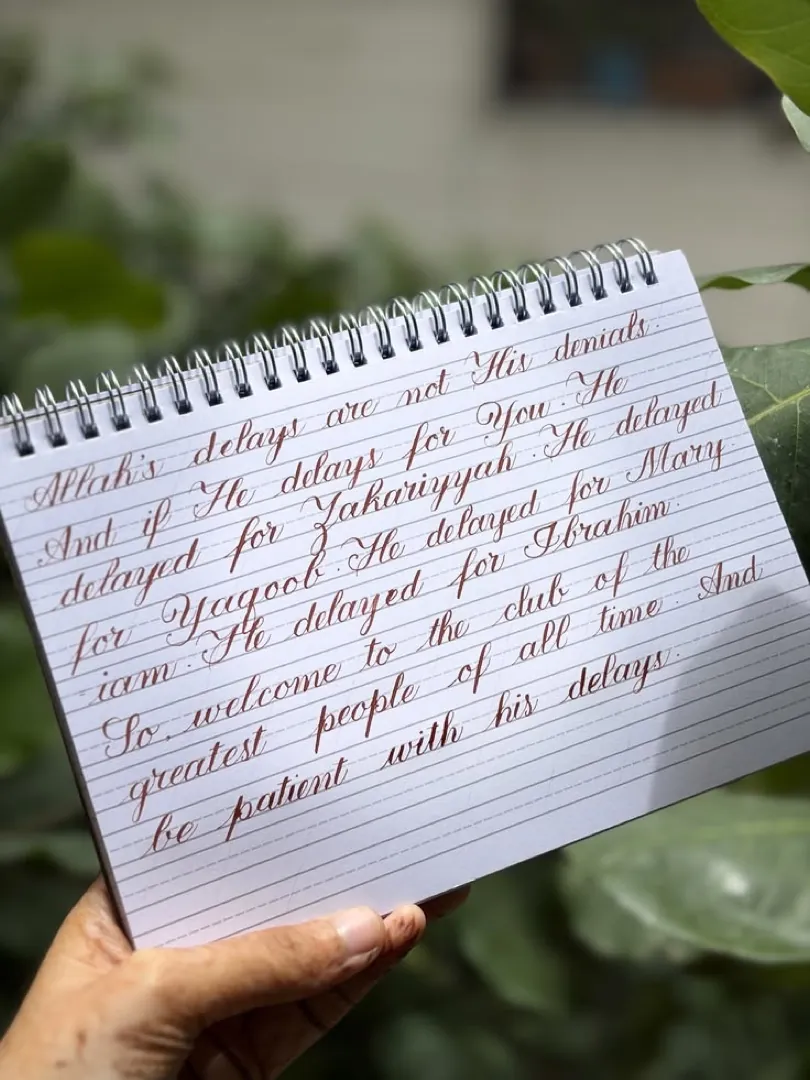 Student work: calligraphy practice page held in hand